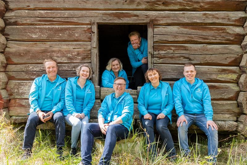 Someron Säästöpankin asiantuntijoiden ryhmäkuva aitan edustalla.
