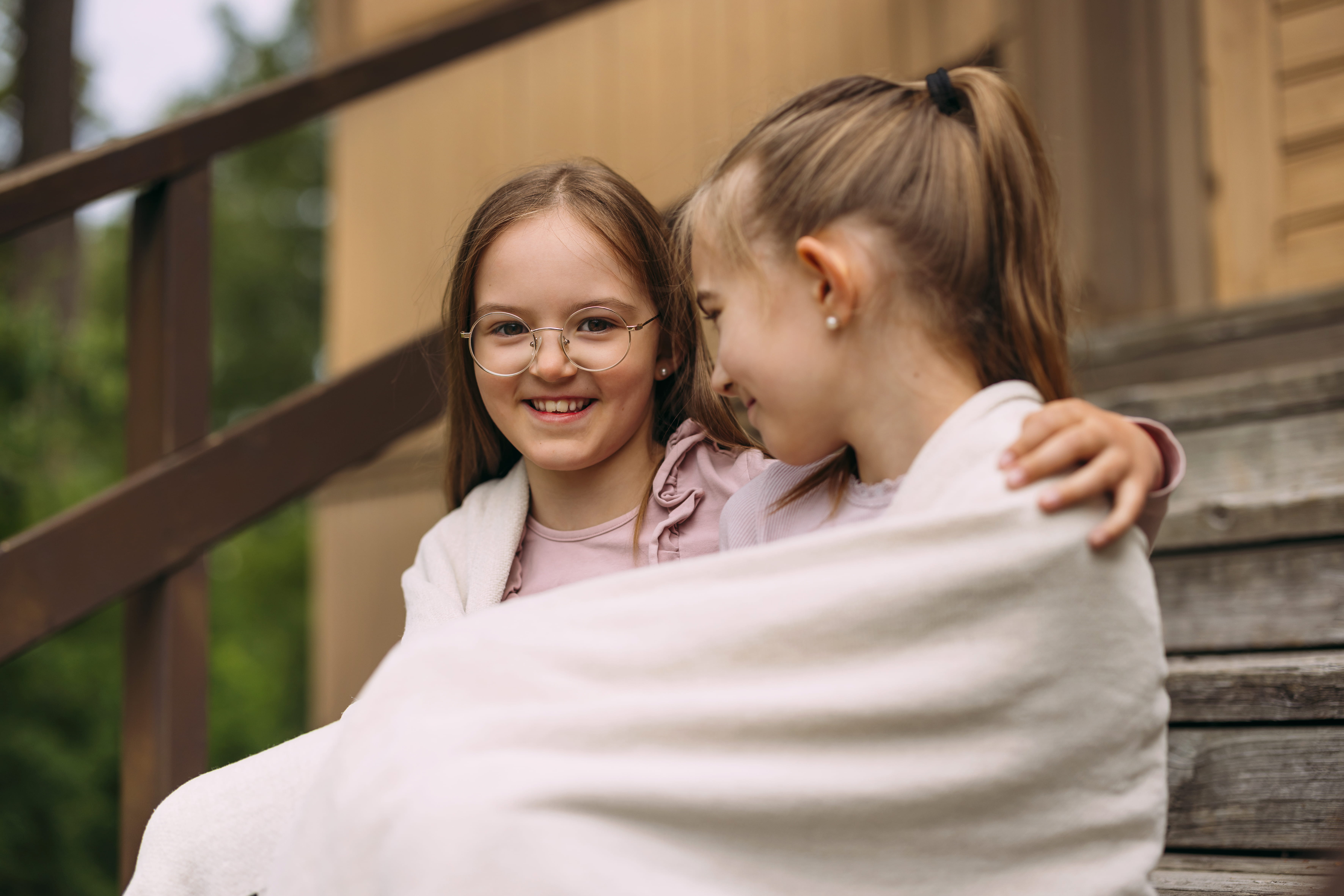 Kaksi nuorta tyttöä, ystävät, halaavat toisiaan.