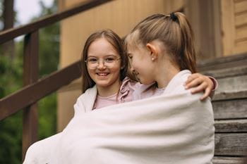 Kaksi nuorta tyttöä, ystävät, halaavat toisiaan.